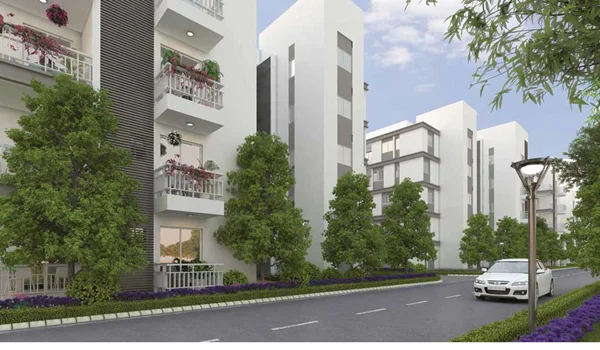 Exterior view of Godrej E-City low-rise residential towers in Electronic City Phase 1 featuring extensive landscaped gardens and clay-brick architecture.